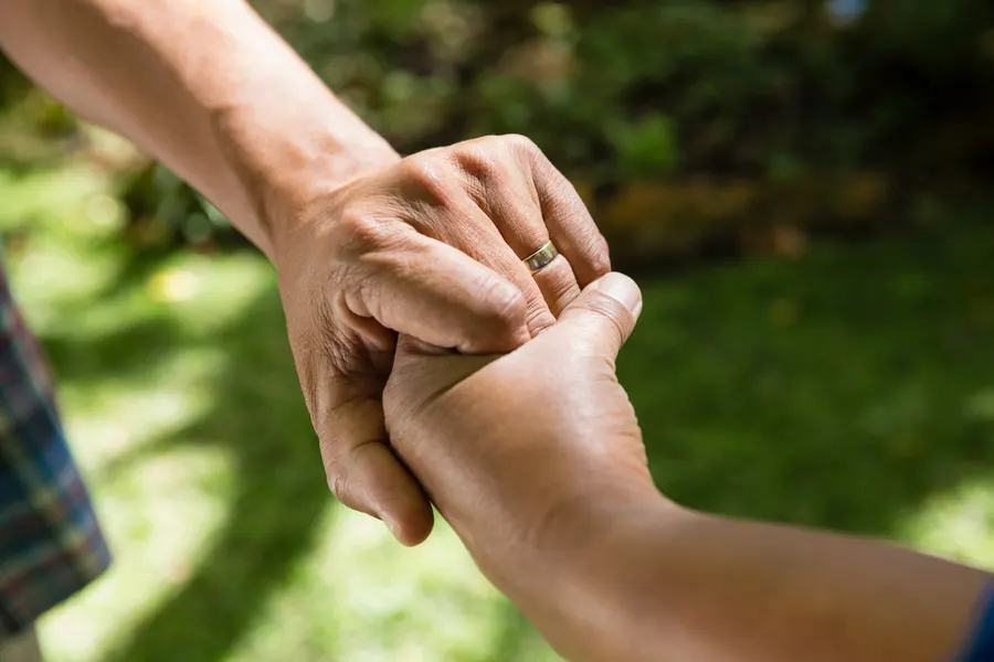 Two people holding hands outdoors