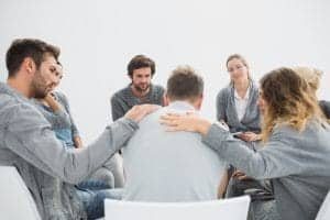 Group therapy for co-occurring disorders in session sitting in a circle with therapist