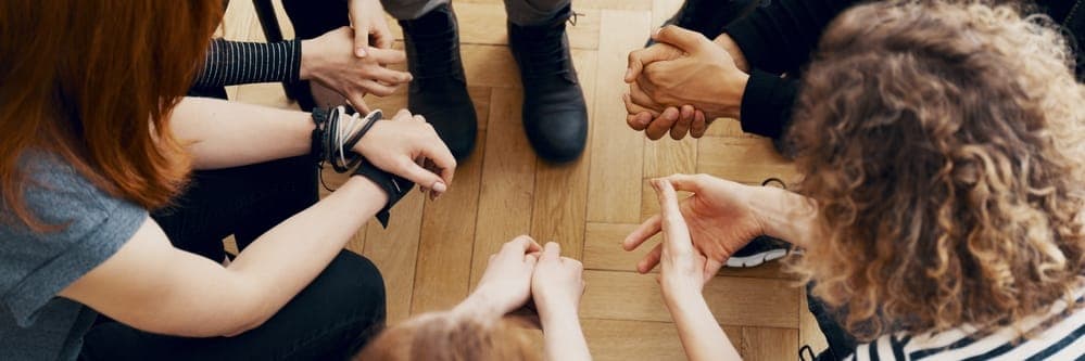 High angle view of hands of people in group therapy at a fentanyl rehab center