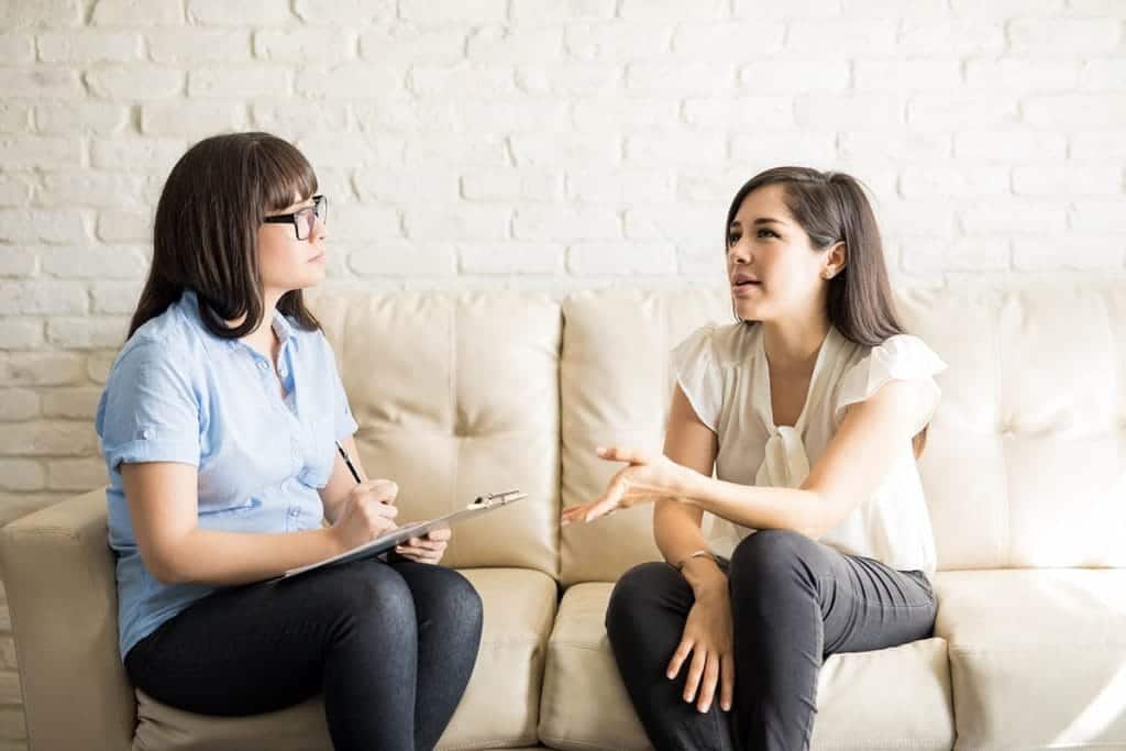   counselor and patient sitting on couch min