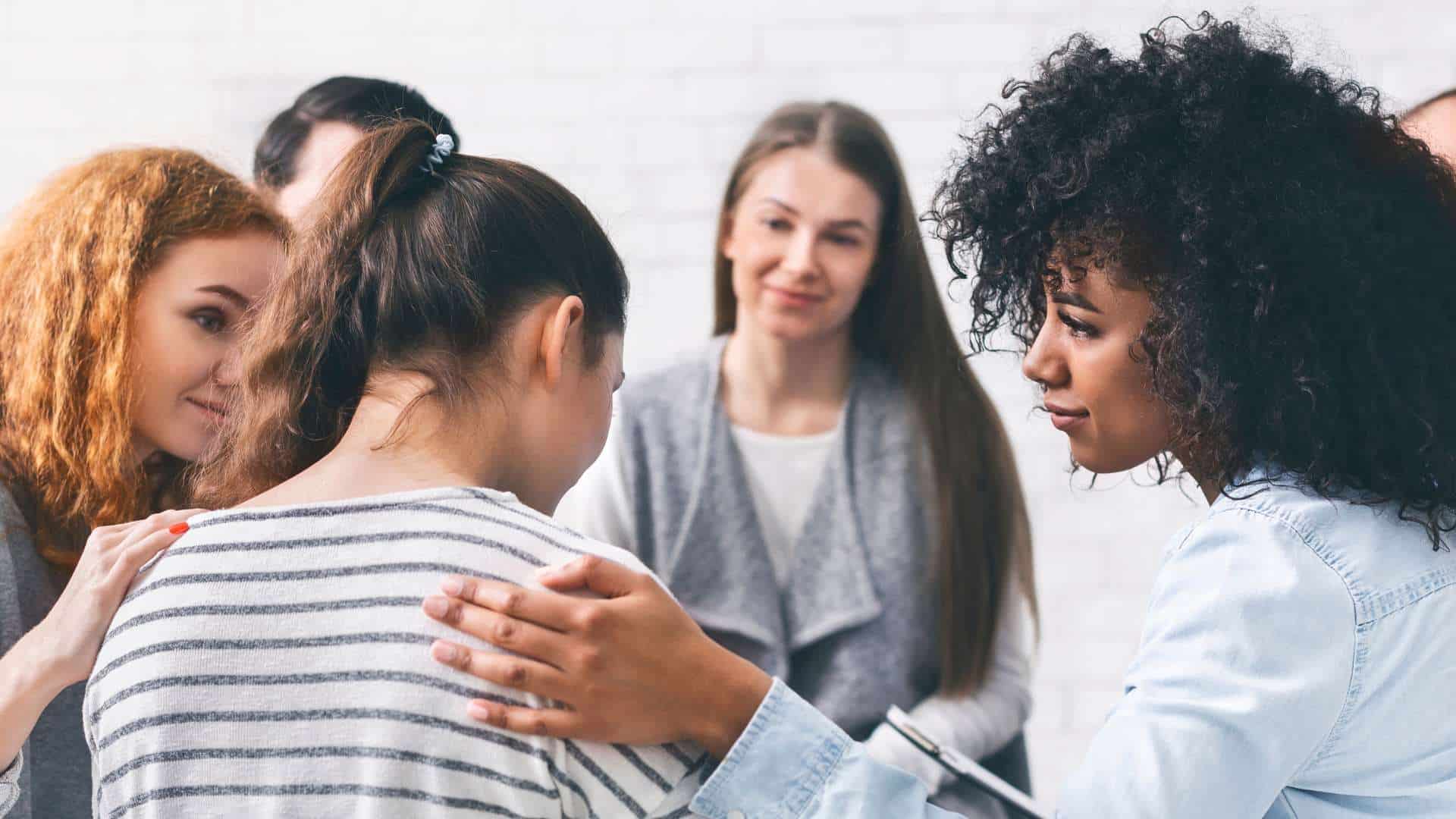  Addiction Aftercare Featured Image Group Therapy Session Women Comforting Participant