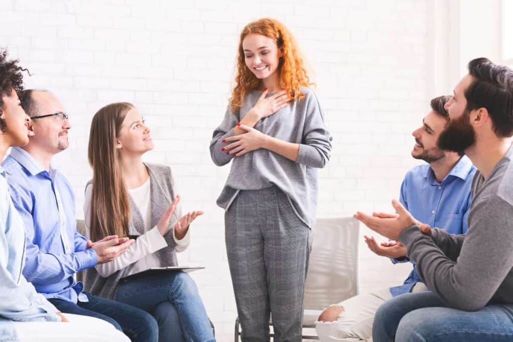  Happy drug addicted woman grateful for group support in rehab