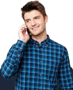 Man in a blue plaid shirt talking on a cellphone with a slight smile, looking to the side.